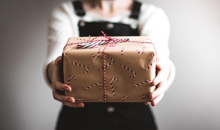 girl holding present out towards you