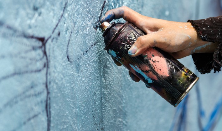 street artist draws with spray paint can