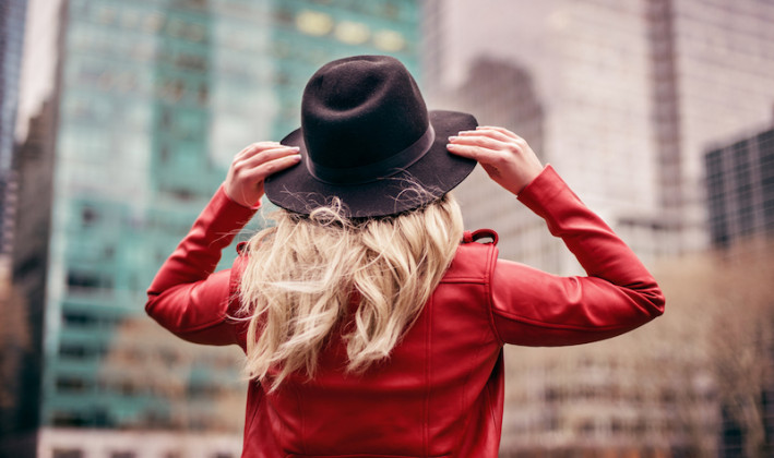 girl looking up from behind with blonde hair red leather jacket and felt hat