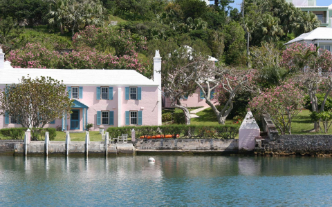 Pink building surrounded by greenery overlooking water