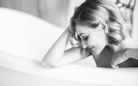 View of an elegant woman relaxing at a bathtub