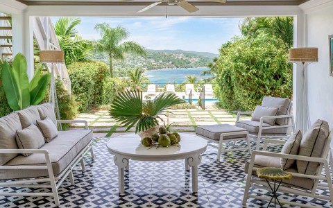 covered patio of villa with tan furniture and succulent accents