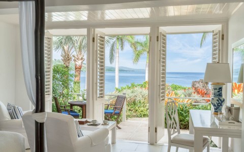 balcony with brown wooden chairs facing the ocean