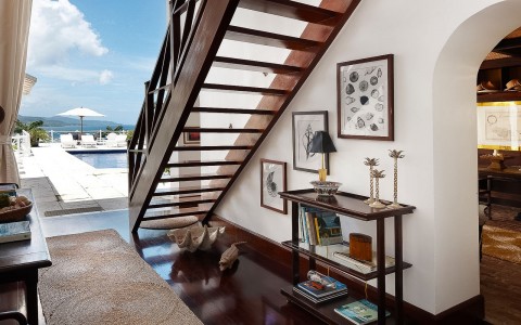 brown wooden staircase in a villa with a bookshelf underneath