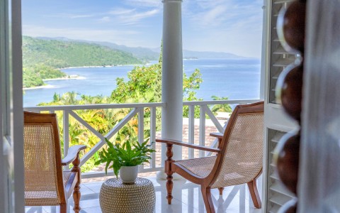detail shot of ocean view balcony with brown chairs and a plant