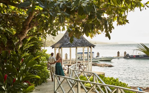 couple walking down the gazebo to the boat doc
