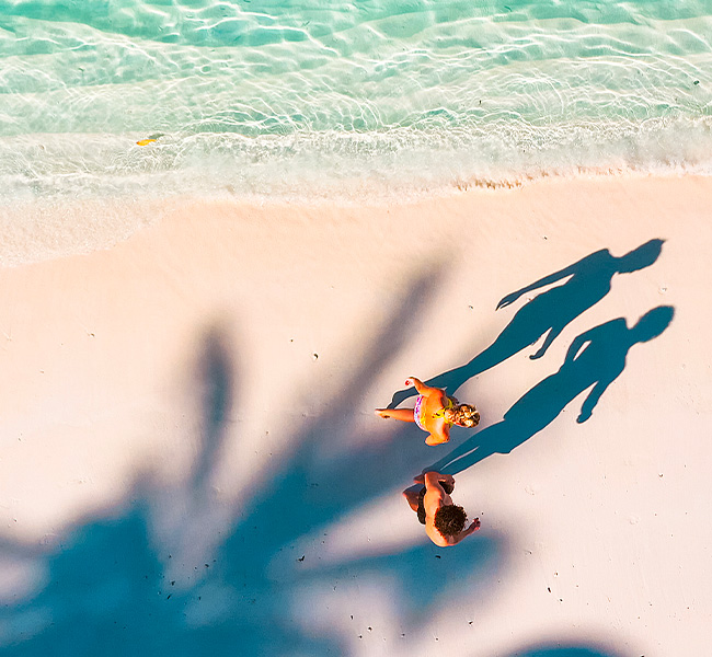 Overhead of couple walking a along shoreline