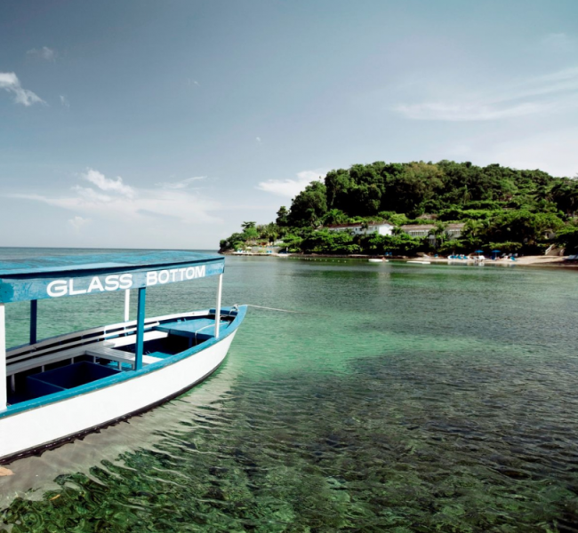 glass bottom boat in ocean with island in background