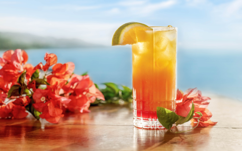 orange and yellow cocktail set on a table overlooking the ocean