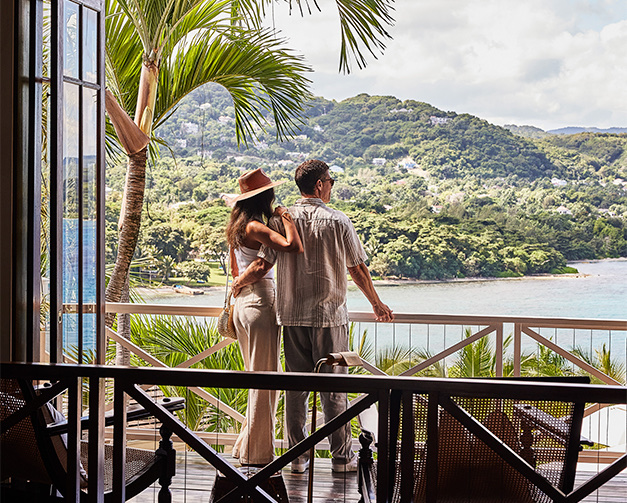 couple standing on the terrace looking out to the view and ocean