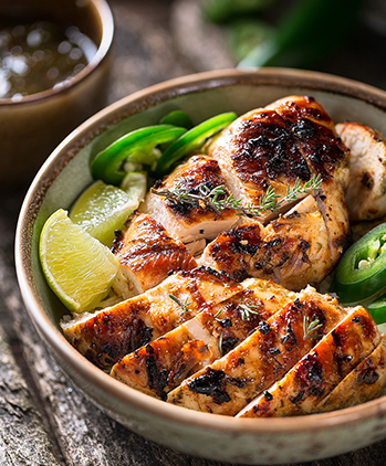 View of a grilled chicken dish with jalapenos and lemon 