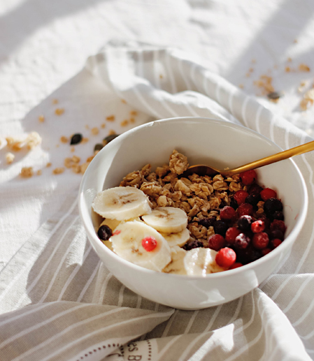 View of a bowl with banana, granola and berries