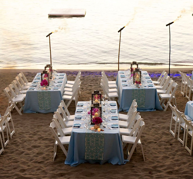 Some tables decorated for a wedding celebration at a seashore 
