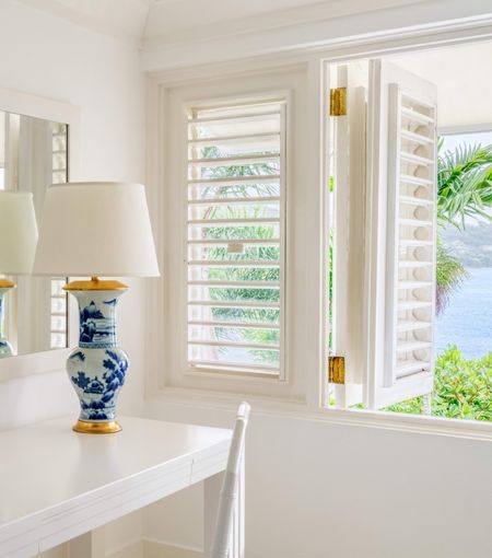 a beautiful blue white and gold lamp with a window and view