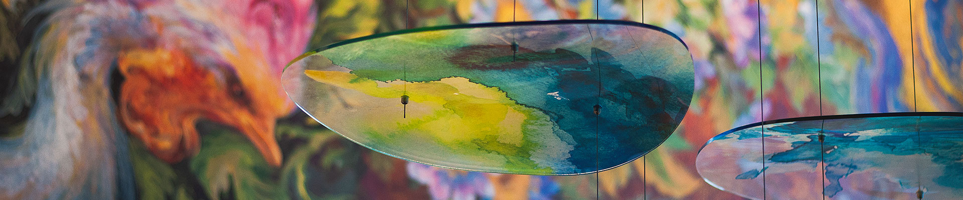 Close up of glass lamp structure next to mural