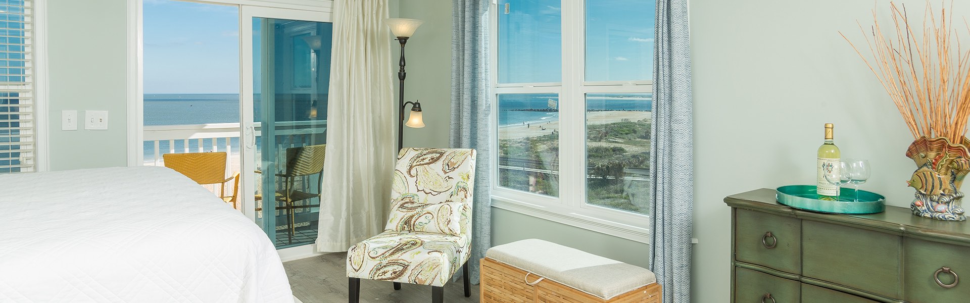 Room with chair next to private balcony with ocean view