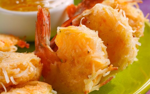 close up of fried shrimp with a sauce on the side