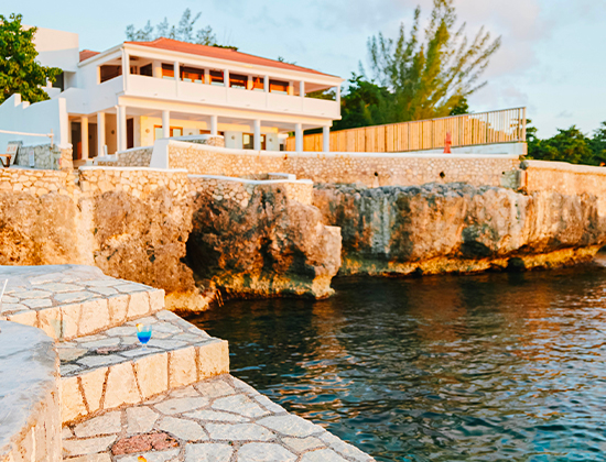 exterior view of resort building with steps from ocean during twilight
