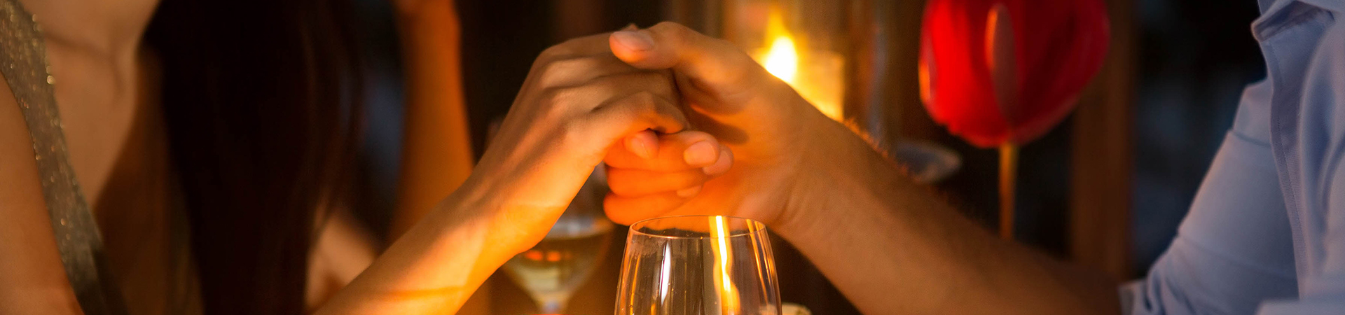 couple holding hands at a romantic dinner setting