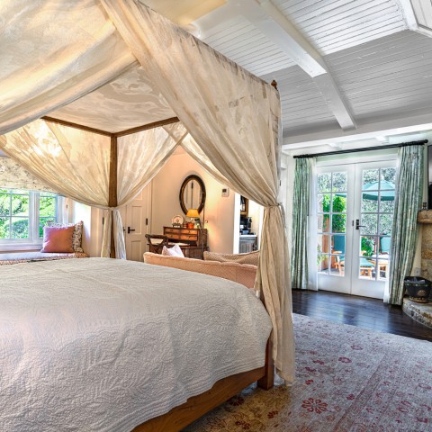 jasmine cottage bedroom with fireplace and doors to outdoor patio