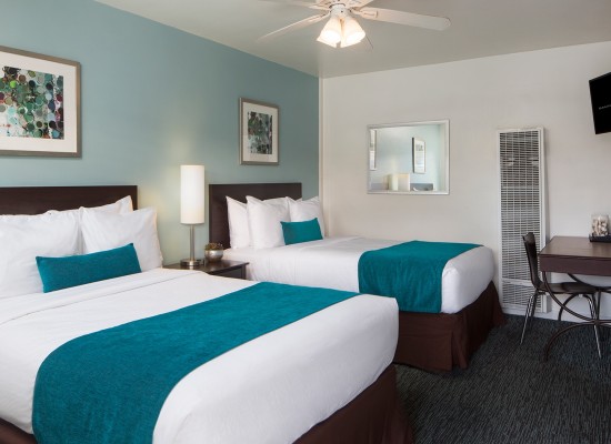 Guest room with two beds with teal accents