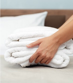 hands setting down folded white towels