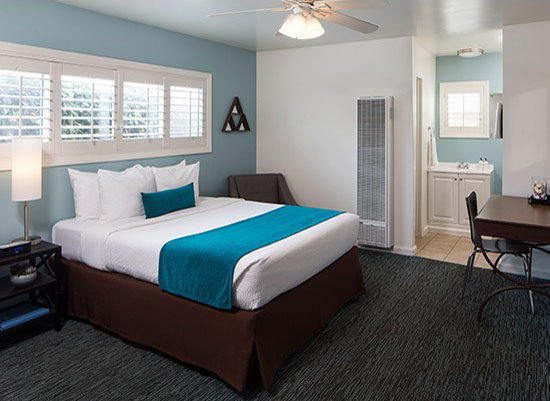 Guest room with bed with teal accent against blue wall