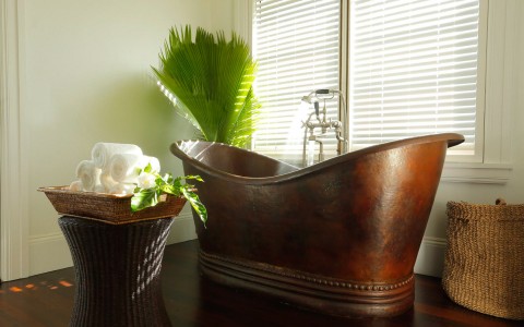 closeup view of a traditional and small bathtub with some decoration and small towels around