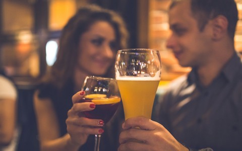 Woman & man toasting with wine & beer