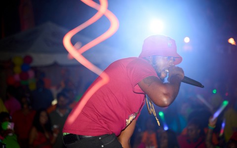 man in red shirt and red bucket hat holding microphone