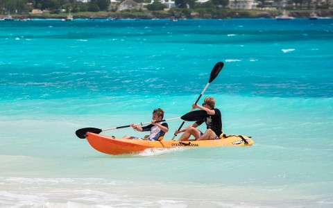 boy and dad kayaking in ocean