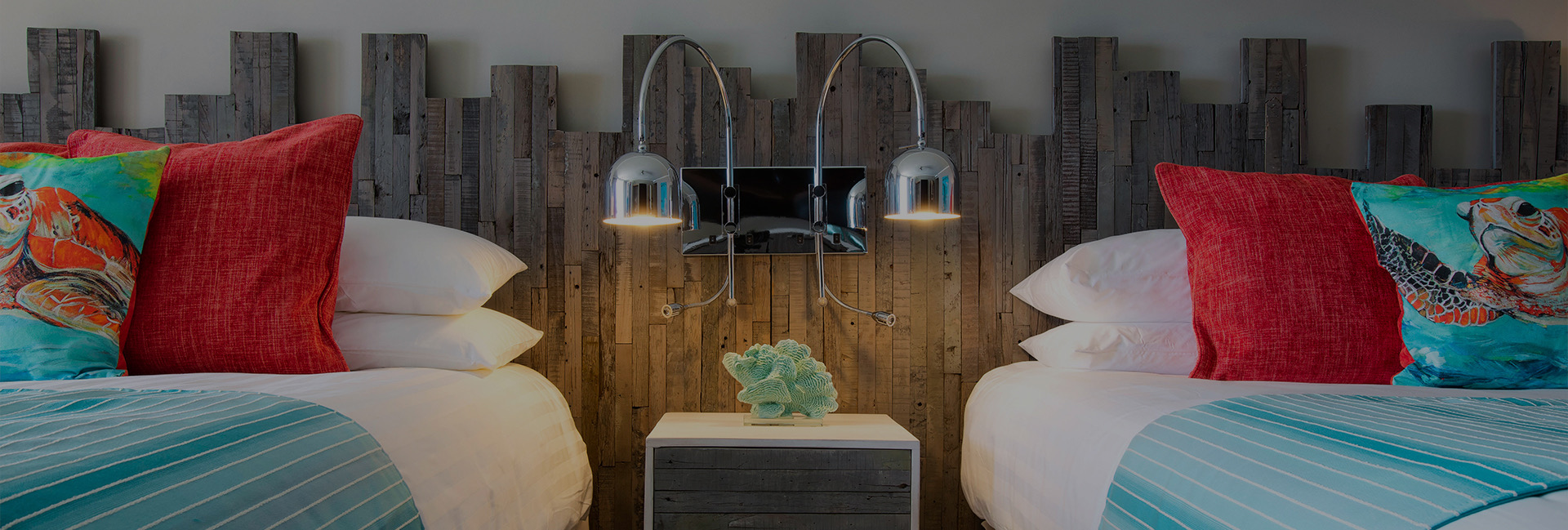 close up of 2 beds with red and turtle pillows