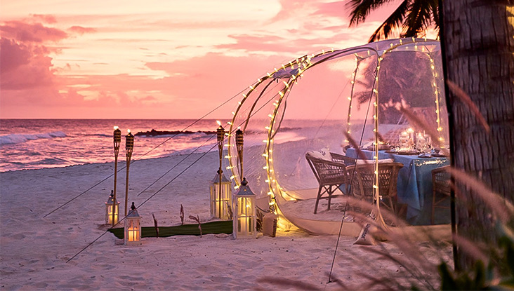 View of a beach with some lanterns and romantic decoration at sunset