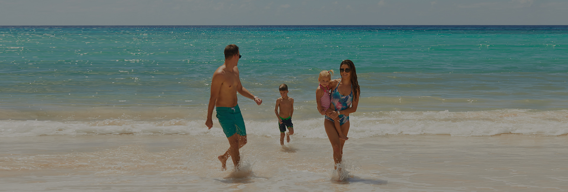 family running up the beach
