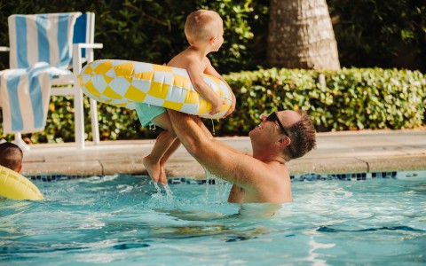dad and son playing in the pool