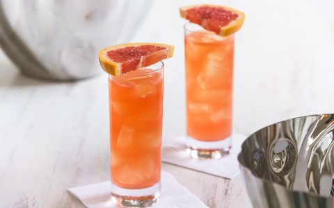 Two orange cocktails with grapefruit slice on top 