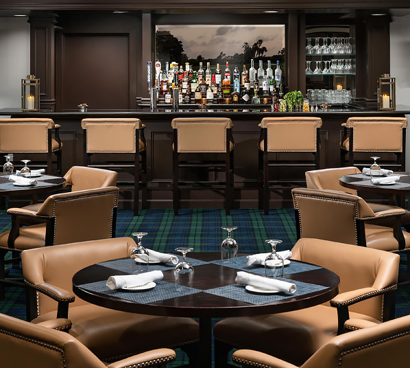 Interior of country club with stool chairs in the back and three set tables