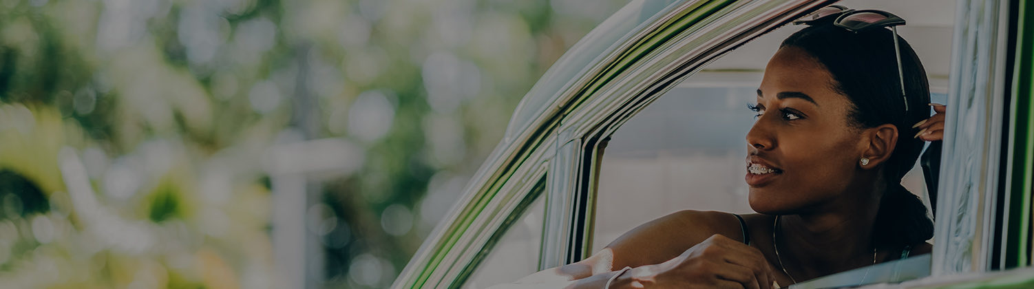 relaxed woman on roadtrip leaning out car window