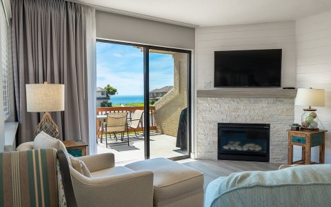 Beige lounger in front of fire place by the balcony door