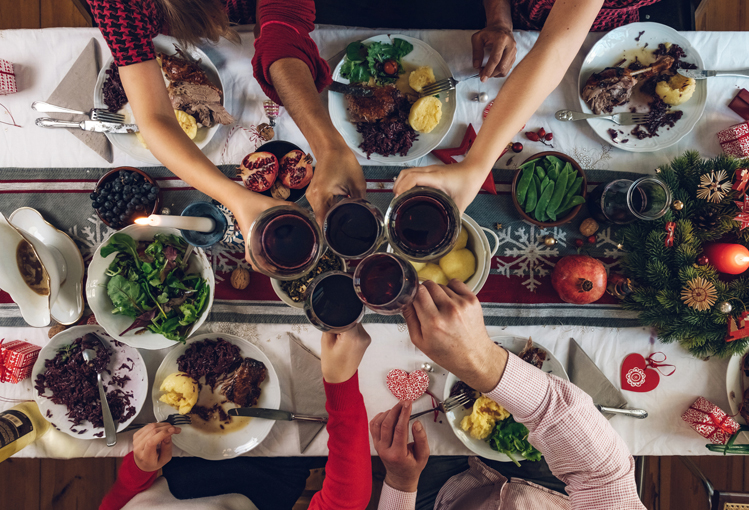 people holding glasses at a holiday dinner table
