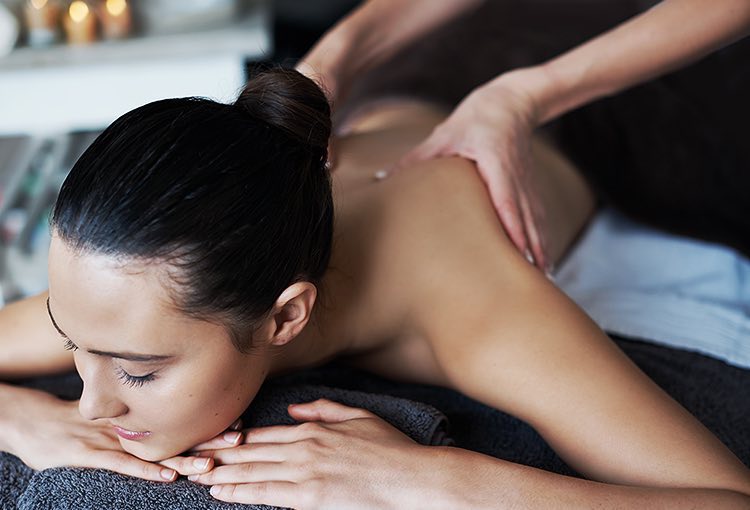 Woman laying down on her stomach getting massage