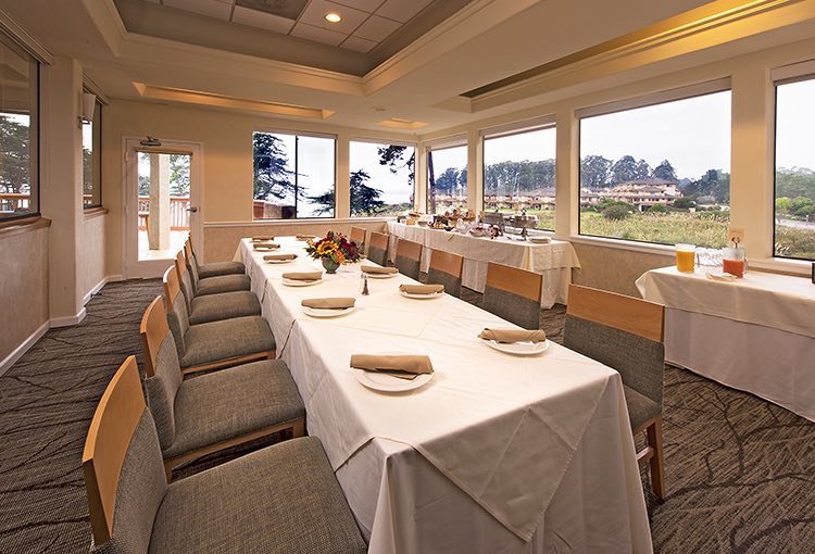 Long rectangular table with plate at each chair and buffet by window
