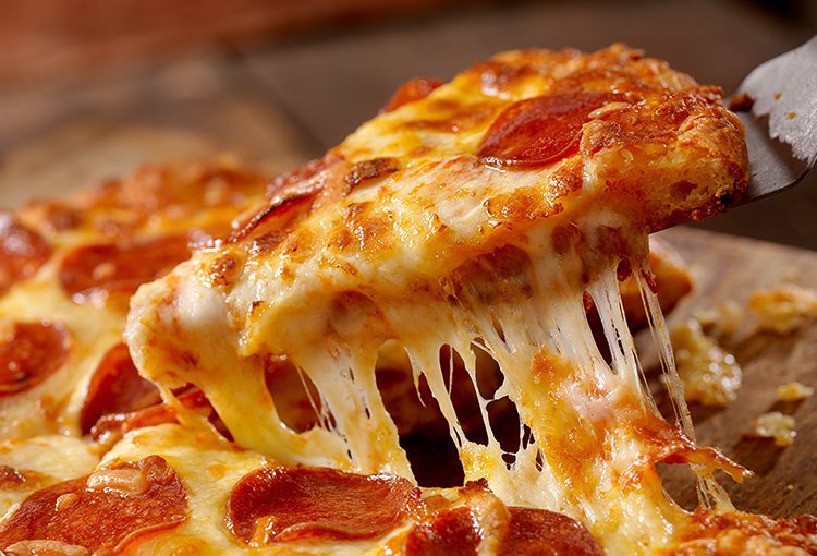 close up of a slice of pizza being cut from a pie