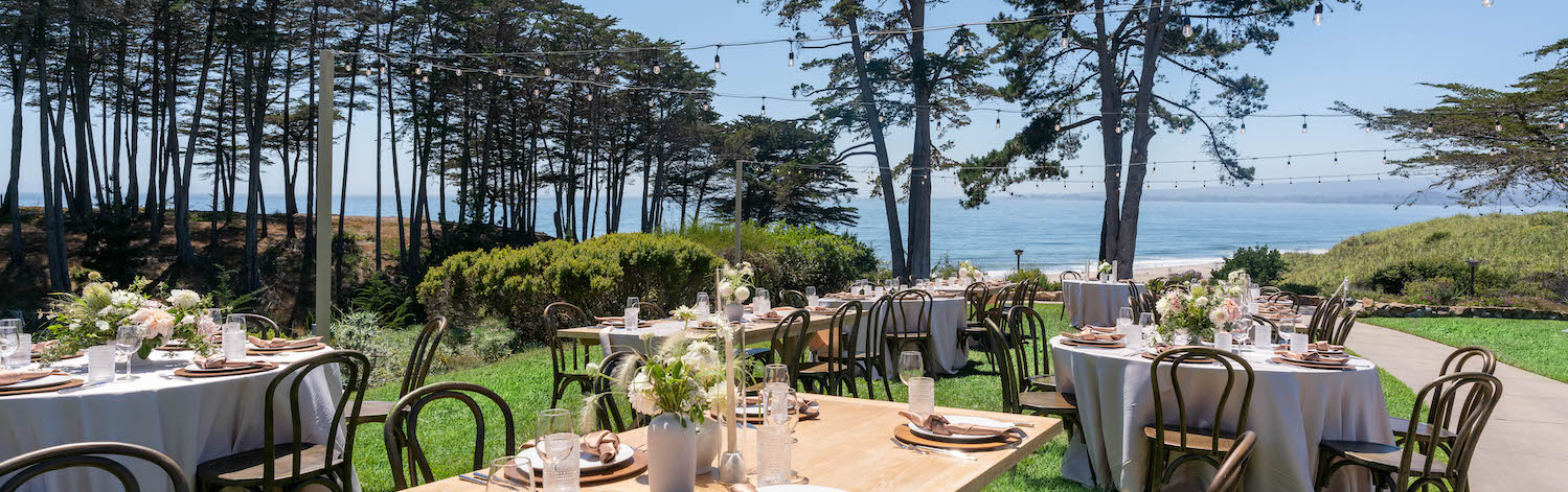 wedding exterior view with ocean and decorated tables