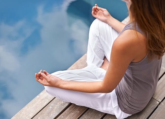woman meditating on a dock
