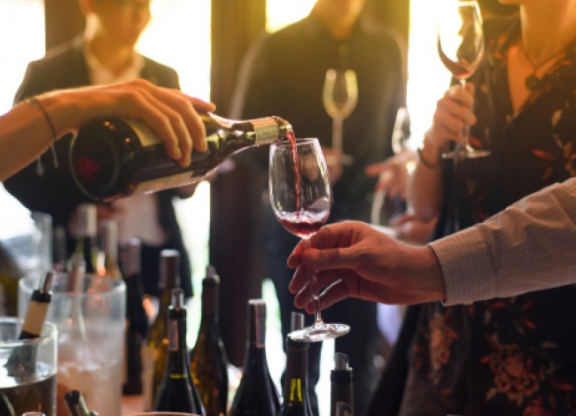 waitress pouring a glass of red wine