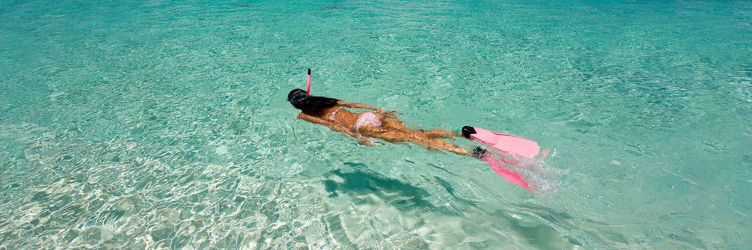 Woman snorkeling in shallow ocean water