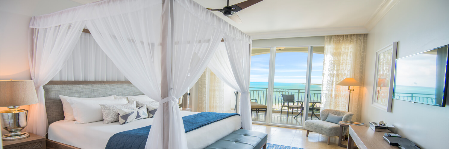 bedroom with canopy bed and sliding glass doors to balcony