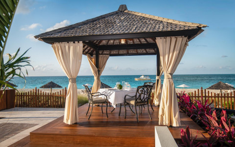 private outdoor dining with table and chairs under cabana