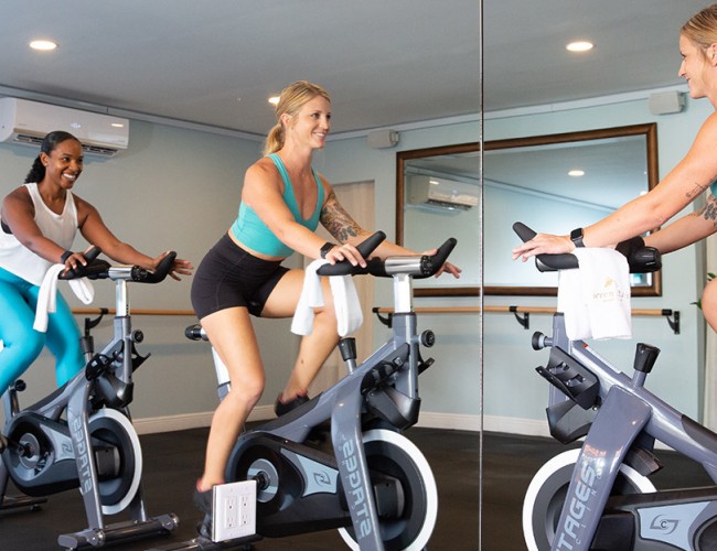 two women cycling in a gym room